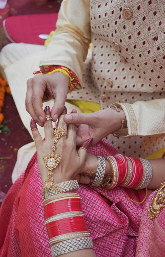 Close-up of intricate jewelry and attire during a traditional Indian wedding ceremony emphasizing cultural richness.